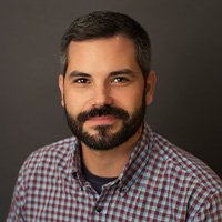 Man with a beard wearing a plaid shirt.