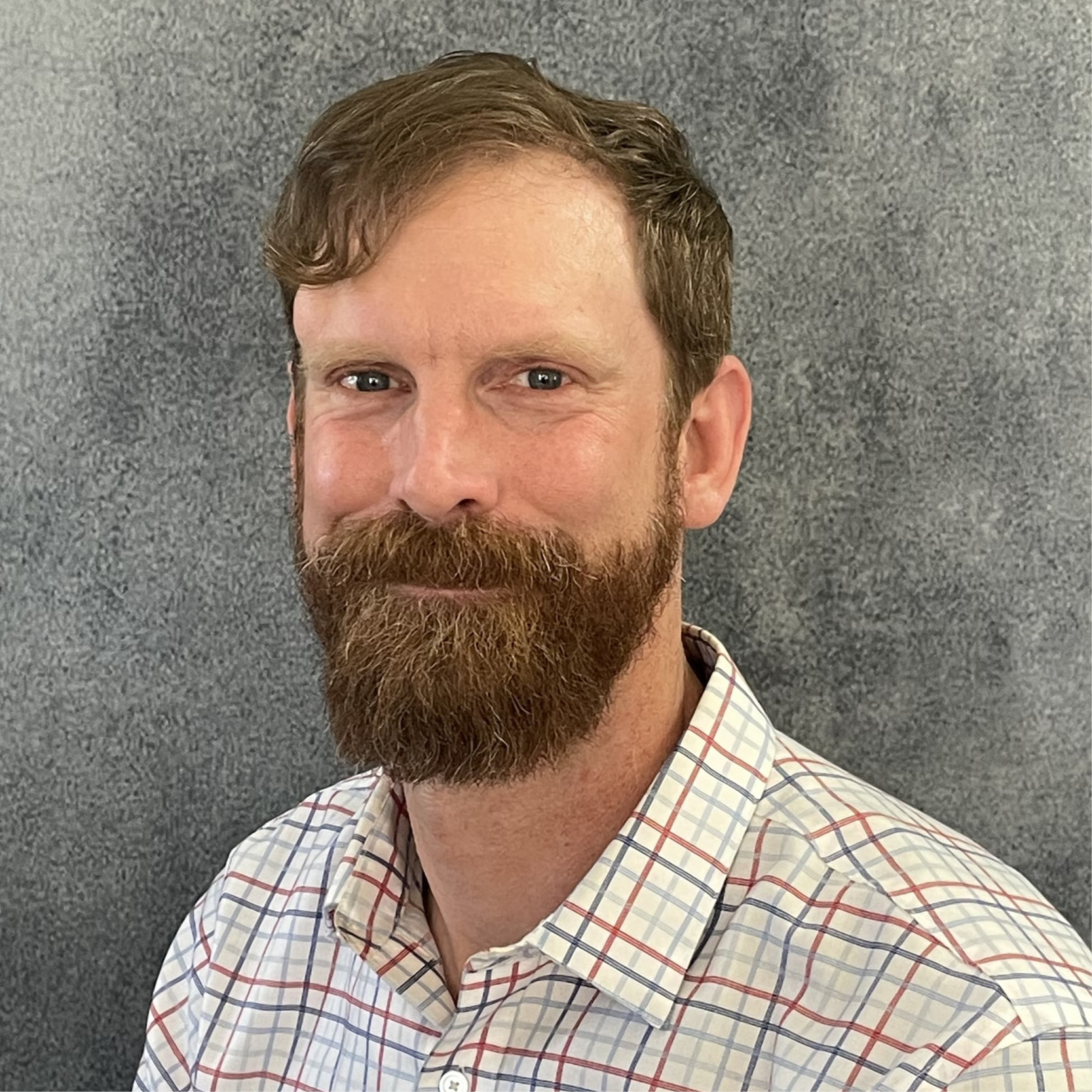 A man with a beard smiling at the camera.